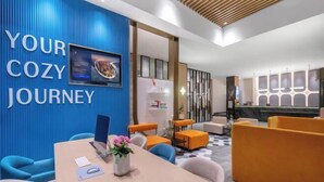 A modern hotel lobby with a blue wall displaying "YOUR COZY JOURNEY" and a reception desk. - Jinjiang Inn (Wenzhou Railway Station) (Wenzhou)
