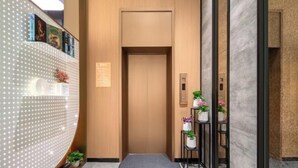 A modern elevator with a wooden finish, a digital display, and a small potted plant on the right. - Jinjiang Inn (Wenzhou Railway Station) (Wenzhou)