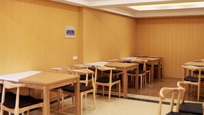 A conference room with wooden tables and chairs, a white ceiling, and a wooden wall.
