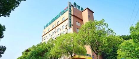 A multi-story hotel with a sign indicating it offers accommodation and possibly other services.