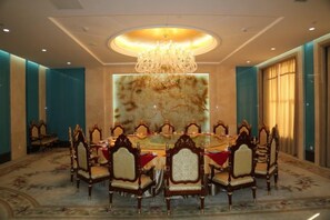 A conference room with a round table, ornate chairs, and a chandelier. - Furunge Hotel (Qingdao)