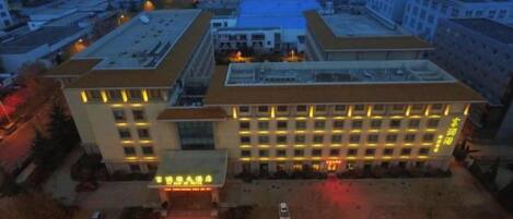 A multi-story hotel with a central courtyard, surrounded by other buildings.