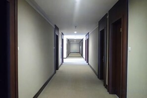 Un pasillo de hotel con puertas a ambos lados, que conduce a habitaciones.