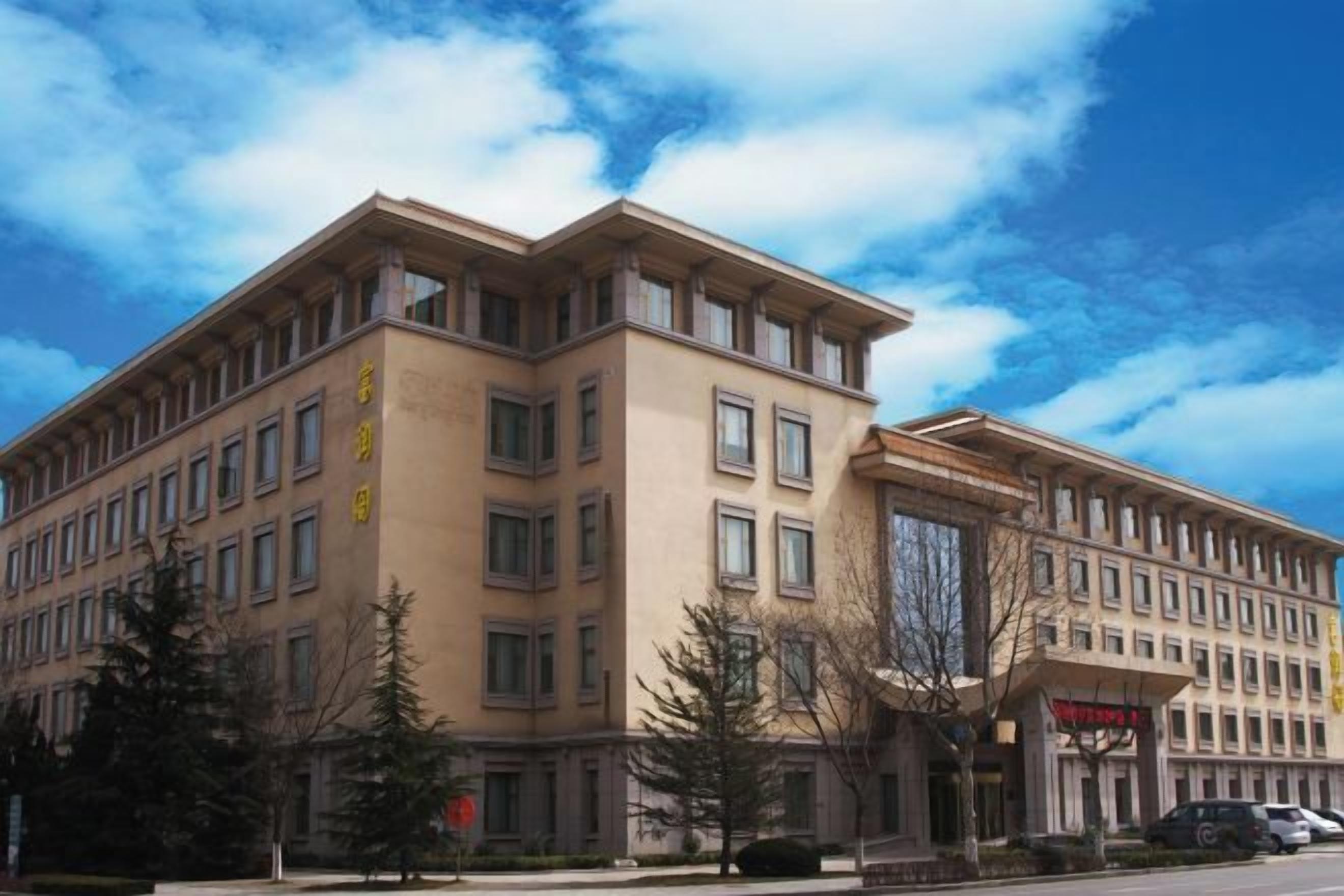 A multi-story building with a symmetrical facade, large windows, and a flat roof.