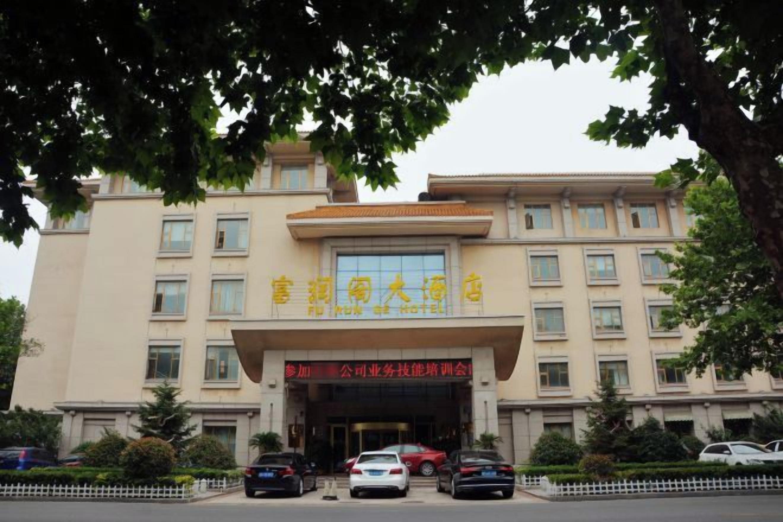 A multi-story building with a large entrance and several windows.