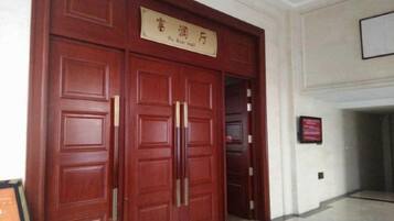 A large wooden double door with a sign above it.