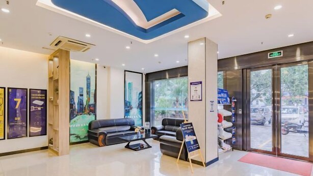 A modern hotel lobby with a reception desk, seating area, and large windows. - Golden Season Chain Hotel (Huizhou)