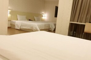 A hotel room with a bed, a nightstand, and a lamp. - Golden Season Chain Hotel (Huizhou)