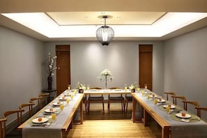 A dining room with a long table set for a meal, chairs on both sides, and a chandelier. - Oriental Yucai Hotel (Foshan Ceramics Headquarters Base Huyong Subway Station) (Foshan)