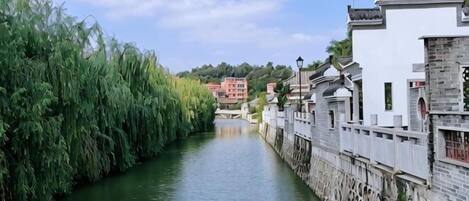 Un canal estrecho bordeado por edificios tradicionales con muros de piedra y techos de tejas.