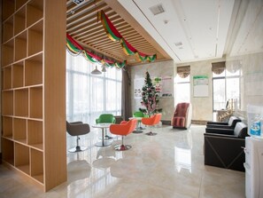 A modern lobby with a wooden bookshelf, a Christmas tree, and a massage chair.