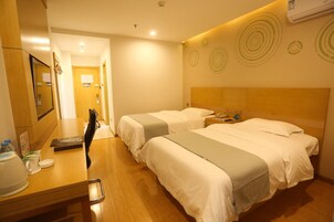 Habitación de hotel con dos camas, un escritorio con teléfono y un espejo.