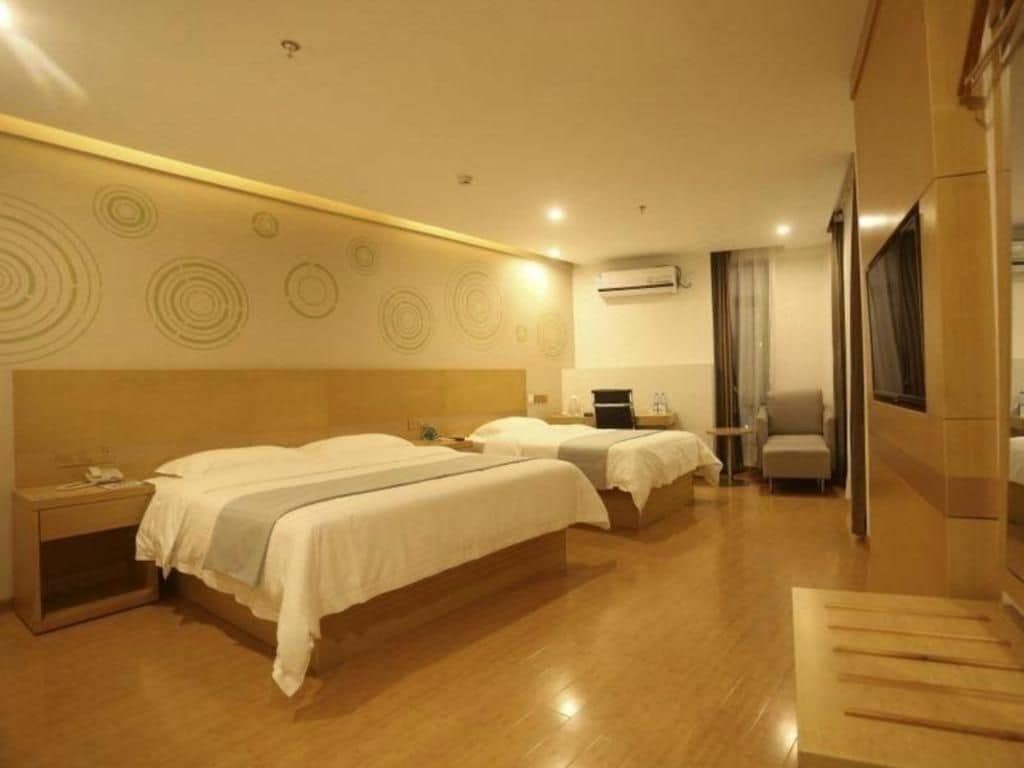 Habitación de hotel con dos camas, un escritorio y una silla.