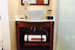 A bathroom with a white sink, a mirror above it, and a towel warmer below. - S One Hotel (Shanghai)