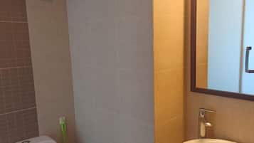 Une salle de bain avec des toilettes, un lavabo et un miroir.