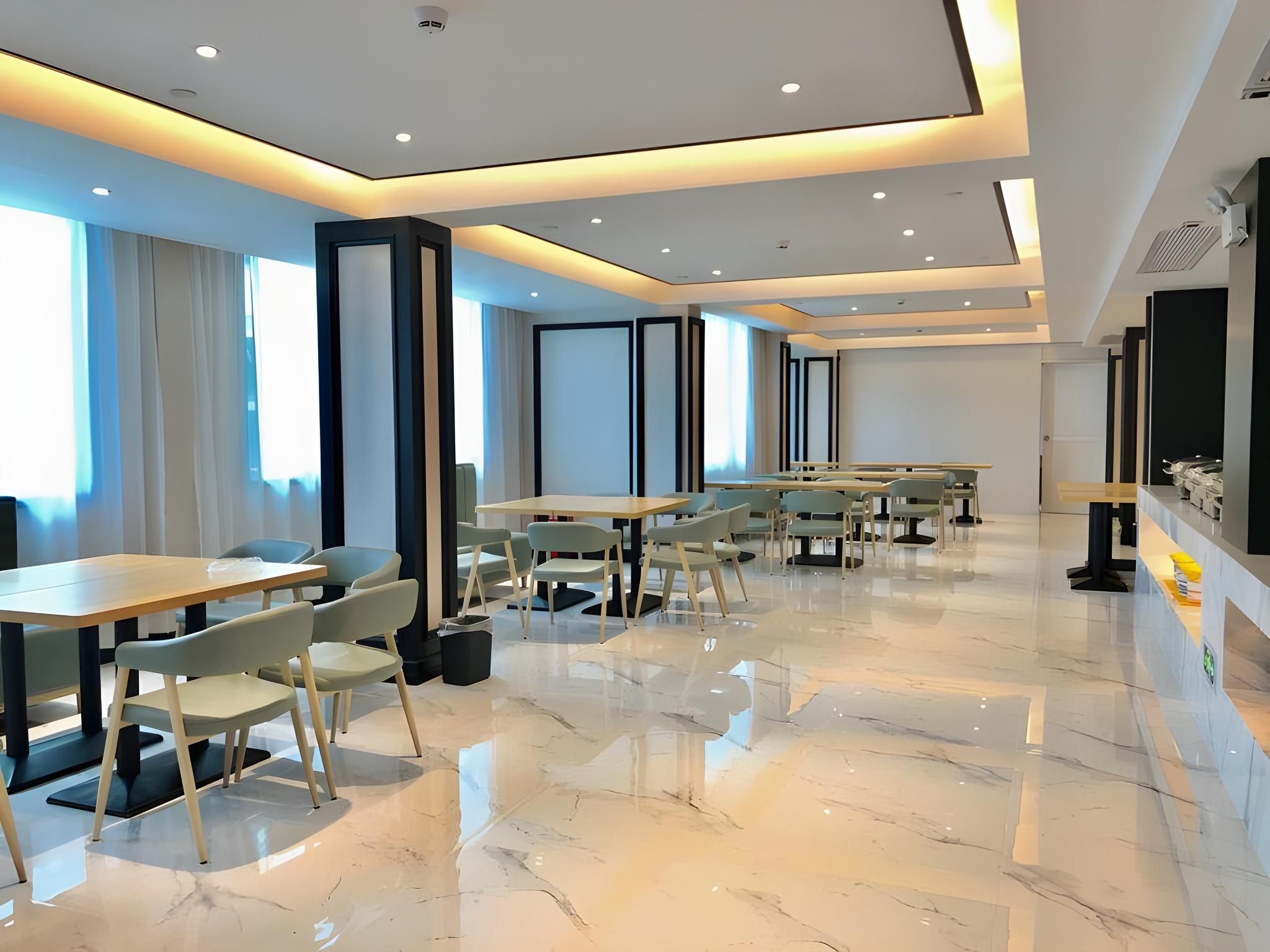 A modern conference room with a long table and chairs, large windows, and a clean, polished floor.