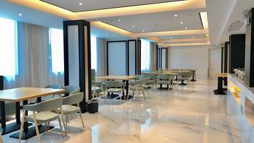 A modern conference room with a long table and chairs, large windows, and a clean, polished floor.