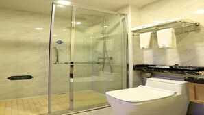 A modern bathroom with a glass-enclosed shower, a white toilet, and a vanity with a towel rack. - Chonpines Hotel (Guangzhou)