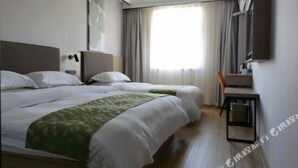 Ett hotellrum med två sängar, ett skrivbord och en stol.