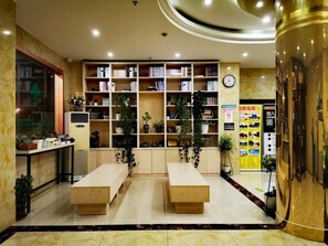 A hotel lobby with a reception desk, a large bookshelf, and a seating area. - Greentree Inn Shanghai Car Piers Studio Beisong Ro (Shanghai)