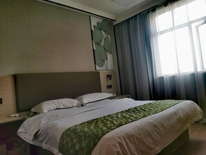 A hotel room with a large bed, a nightstand, a wall-mounted clock, and a window with curtains. - Greentree Inn Shanghai Car Piers Studio Beisong Ro (Shanghai)