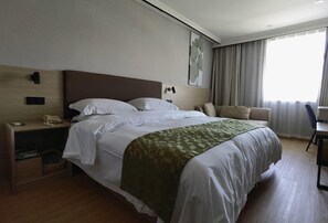 A hotel room with a large bed, a bedside table with a phone, a lamp, and a wall-mounted control panel. - Greentree Inn Shanghai Car Piers Studio Beisong Ro (Shanghai)