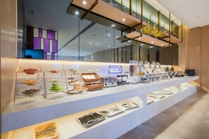 A buffet setup with various food items and utensils.