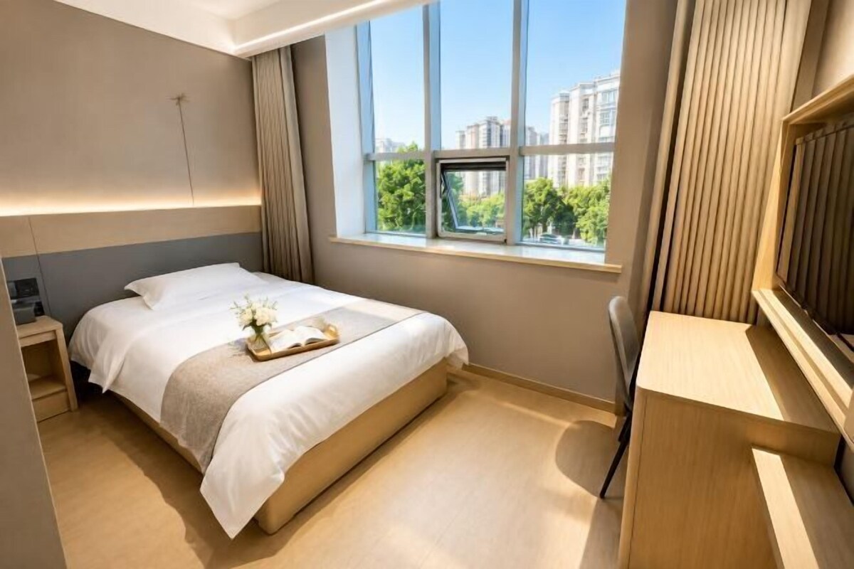 Una habitación de hotel con una cama, una mesita de noche y un escritorio.