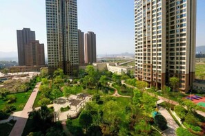 A high-rise residential building complex with multiple apartment buildings, a landscaped garden area, and a clear sky. - 7 Days Premium (Chongqing Liangjiang New District, Yufu Industrial Park, Yuzui) (Chongqing)