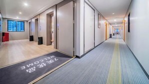 A modern hotel corridor with a carpeted floor, doors leading to rooms, and a welcome mat with text. - 7 Days Premium (Chongqing Liangjiang New District, Yufu Industrial Park, Yuzui) (Chongqing)