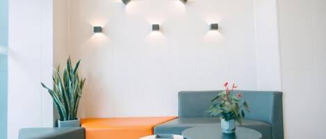 A modern waiting area with a sofa, a small table, and a potted plant.