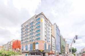 A multi-story building with a corner entrance, large windows, and a visible storefront at street level. - 7Days Inn Hotel (Huizhou Zhongkai Chenjiang Avenue) (Huizhou)