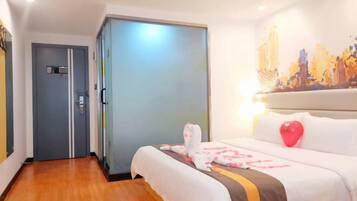 Ein Hotelzimmer mit Bett, Kleiderschrank und einem Stadtbild an der Wand.