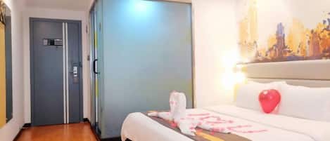 A hotel room with a bed, a wardrobe, and a cityscape painting on the wall.