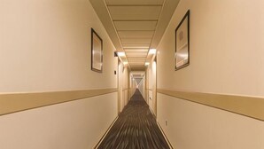 A hotel hallway with carpeted floors, framed pictures on the walls, and a ceiling with recessed lighting. - Jinjiang Inn (Anyang Railway Station) (Anyang)
