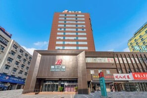 Jinjiang Inn features a modern architectural design with a grid-patterned facade and prominent signage.