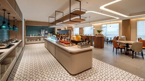 A modern hotel lobby with a central counter, seating area, and a view of the city. - Holiday Inn Express Ziyang City Center by IHG (Ziyang)