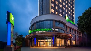 Un hôtel Holiday Inn Express doté d’une façade moderne aux lignes courbes, de grandes fenêtres et d’une enseigne lumineuse.