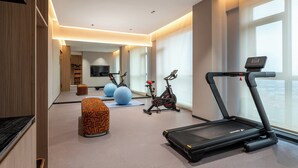 A modern gym with a treadmill, stationary bikes, and exercise balls. - Holiday Inn Express Ziyang City Center by IHG (Ziyang)