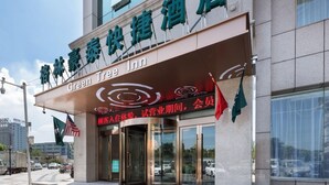 The exterior of the Green Tree Inn hotel with a clear entrance, glass doors, and a signboard displaying the hotel's name in both English and Chinese. - Greentree Inn Changzhou Zhongwu Avenue Jiangsu Uni (Changzhou)