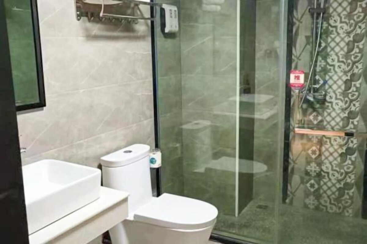 A bathroom with a toilet, a sink, and a glass shower enclosure.