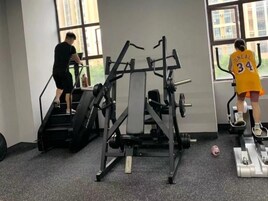 A gym with exercise equipment, including a stair climber and an elliptical machine.