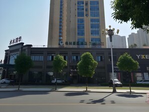 A modern building with multiple floors, large windows, and a sign that reads "Hotel". - Greentree Inn Yingtan Xinjiang New District Munici (Yingtan)
