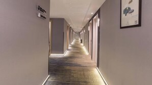 A long, narrow hallway with a carpeted floor and recessed lighting. - Jinjiang Inn (Wuxi New District National Software Park) (Wuxi)