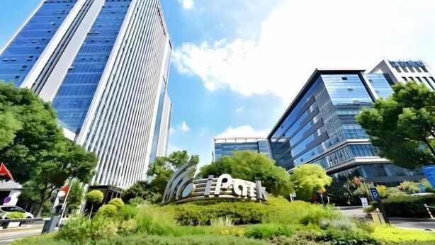 A modern building with a prominent sign in the foreground, surrounded by lush greenery and other high-rise buildings in the background. - Jinjiang Inn (Wuxi New District National Software Park) (Wuxi)