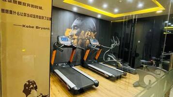 A gym with treadmills, a wall with a poster, and a mirror.