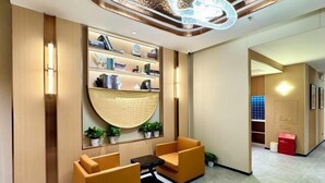 A modern lobby with a seating area, a bookshelf, and a decorative ceiling light. - Jinjiang Inn (Wuxi New District National Software Park) (Wuxi)