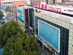 Un edificio comercial grande con varios letreros, incluyendo uno de hotel.