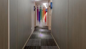 A hallway with a tiled floor and a series of colorful paintbrushes on the wall. - Shell Changzhou University City Science and Educat (Changzhou)