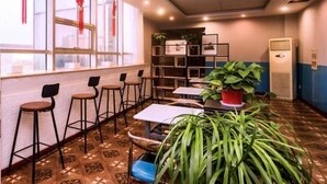 A modern interior with a bar area, seating, a plant, and a wall-mounted air conditioner. - Shell Changzhou University City Science and Educat (Changzhou)